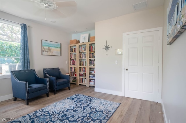 sitting room with light wood-type flooring and ceiling fan