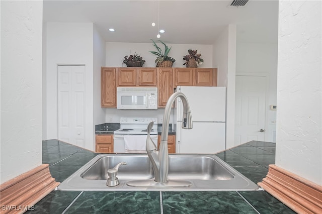 kitchen featuring tile counters, white appliances, and sink