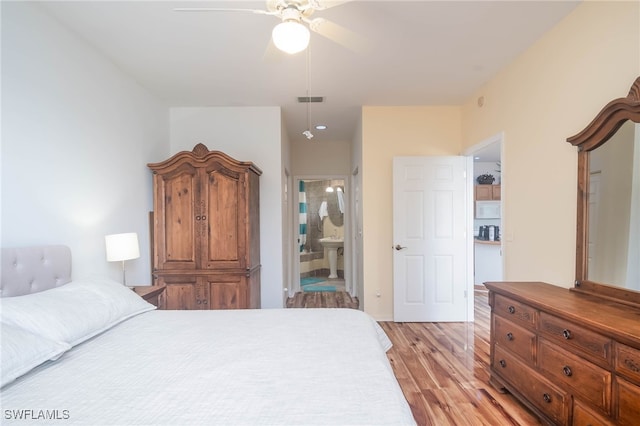 bedroom with ceiling fan, connected bathroom, and light hardwood / wood-style flooring