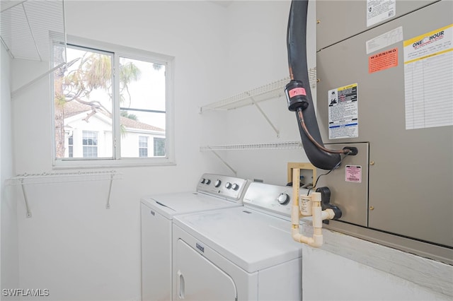 clothes washing area featuring heating unit and independent washer and dryer