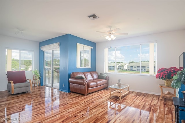 living room with ceiling fan, a healthy amount of sunlight, and light wood-type flooring