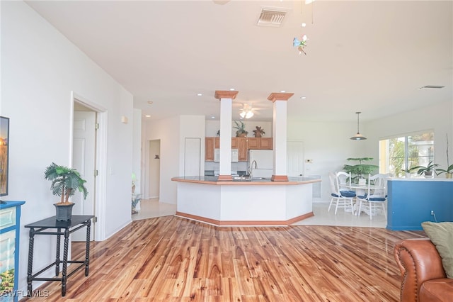 kitchen with pendant lighting, white appliances, ceiling fan, light wood-type flooring, and kitchen peninsula