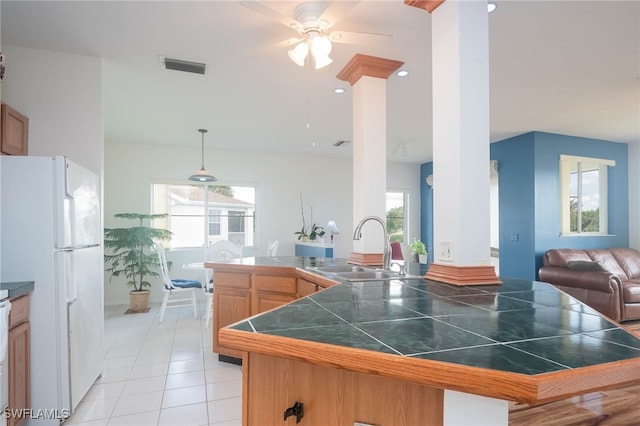 kitchen with sink, hanging light fixtures, ceiling fan, light tile patterned floors, and white fridge