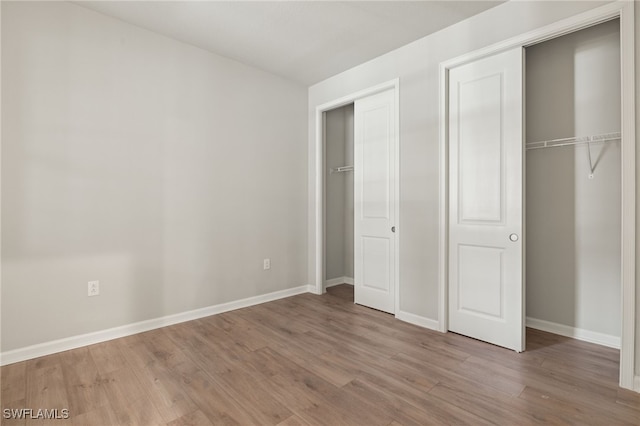 unfurnished bedroom with hardwood / wood-style flooring and a closet