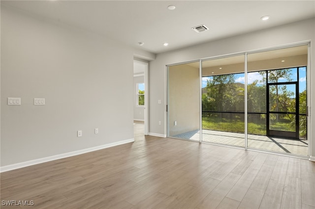 spare room with a healthy amount of sunlight and hardwood / wood-style flooring