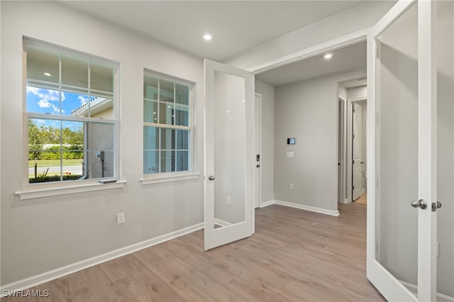 empty room featuring french doors and light hardwood / wood-style floors