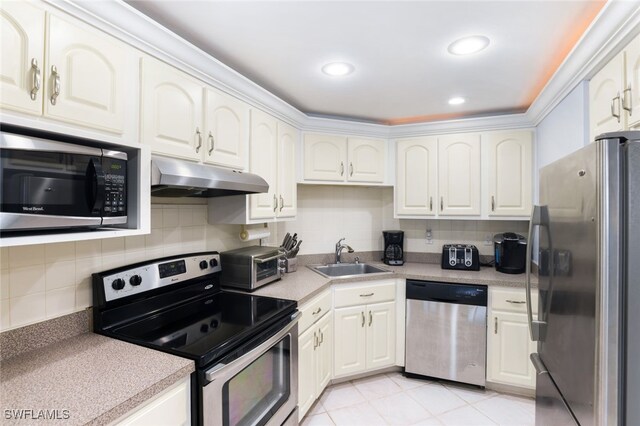 kitchen featuring backsplash, white cabinets, sink, light tile patterned floors, and stainless steel appliances