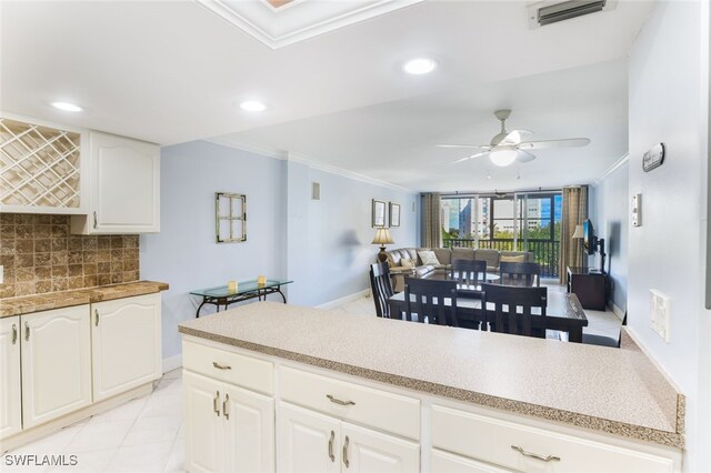 kitchen featuring ceiling fan, light tile patterned floors, crown molding, decorative backsplash, and white cabinets