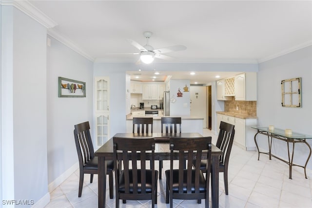 tiled dining room featuring ceiling fan, sink, and ornamental molding