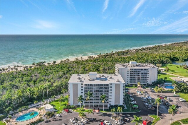 birds eye view of property with a water view and a beach view