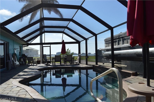 view of swimming pool with glass enclosure and a patio area