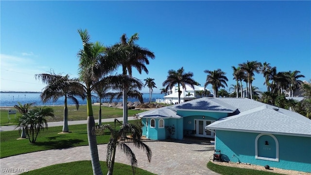 view of front of property with a water view and a front lawn