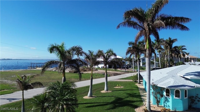 view of home's community with a yard and a water view