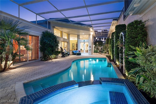 view of pool with glass enclosure, a patio area, and a pool with connected hot tub