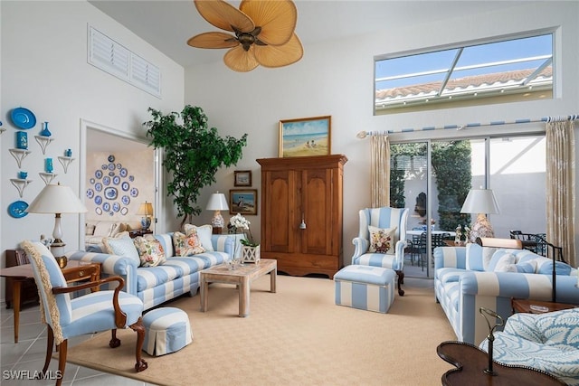 living room with tile patterned floors, ceiling fan, and a towering ceiling