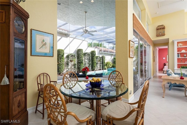 dining room with baseboards, a sunroom, and ceiling fan