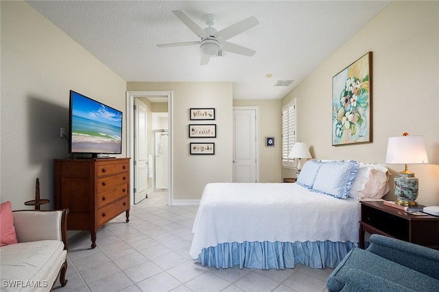 bedroom with visible vents, ensuite bathroom, light tile patterned flooring, baseboards, and ceiling fan