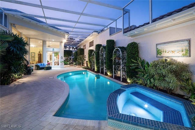 view of swimming pool featuring an in ground hot tub, a lanai, and a patio area