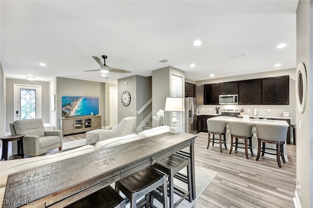 dining area with ceiling fan and light wood-type flooring