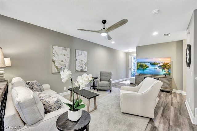 living room with ceiling fan and light hardwood / wood-style flooring