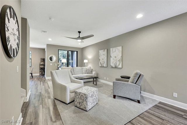 living room featuring light hardwood / wood-style floors and ceiling fan