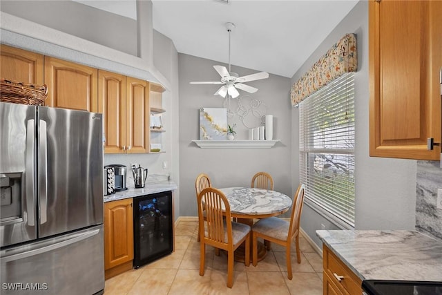 kitchen with ceiling fan, wine cooler, stainless steel fridge, vaulted ceiling, and light tile patterned flooring