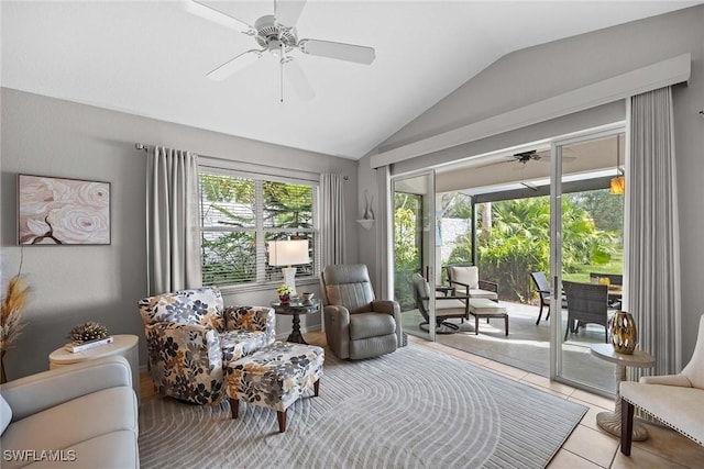 sitting room with ceiling fan, light tile patterned floors, and vaulted ceiling