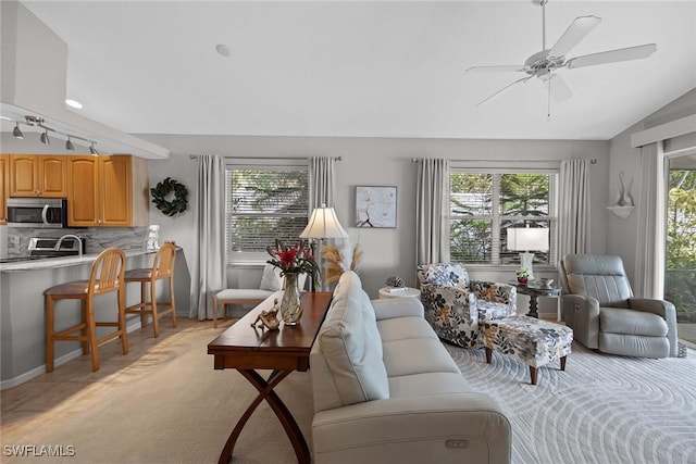 carpeted living room with a wealth of natural light, ceiling fan, and lofted ceiling