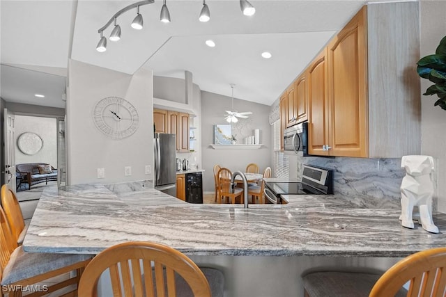 kitchen featuring lofted ceiling, backsplash, ceiling fan, kitchen peninsula, and stainless steel appliances