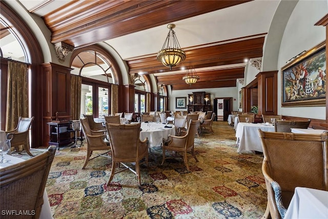 dining room featuring lofted ceiling with beams and an inviting chandelier