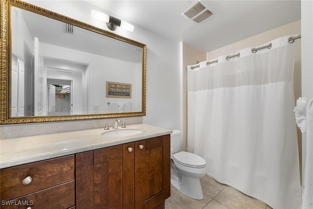 bathroom with toilet, vanity, and tile patterned floors