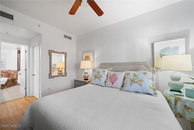 bedroom featuring light hardwood / wood-style floors, ensuite bath, and ceiling fan