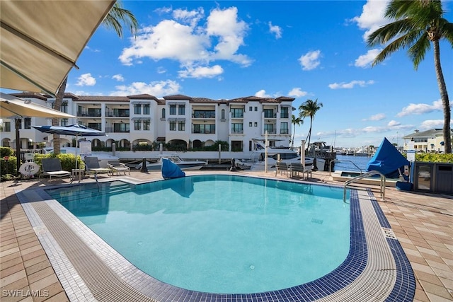 view of swimming pool with a water view and a patio