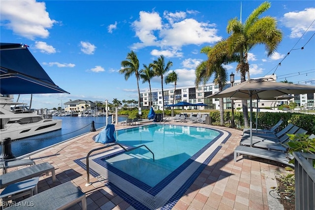 view of pool featuring a patio area and a water view