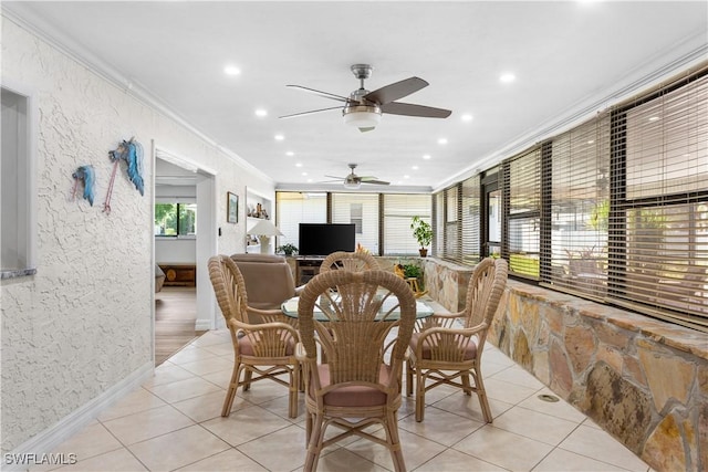 tiled dining room featuring ornamental molding and ceiling fan