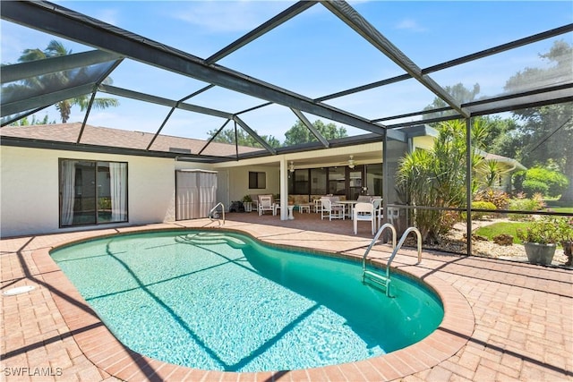 view of swimming pool featuring a lanai and a patio