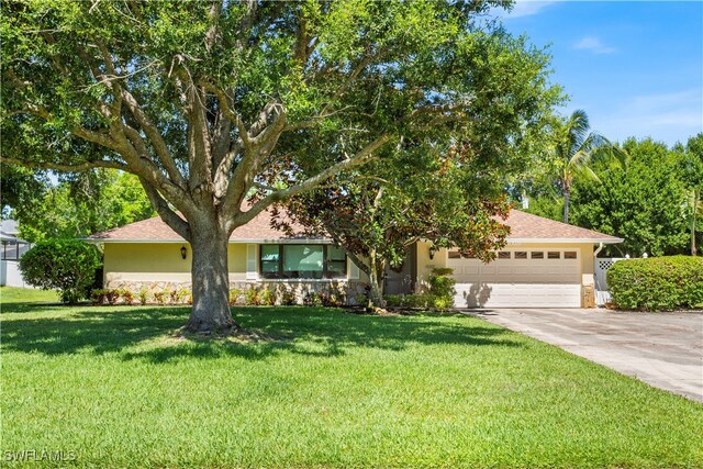 view of front of property with a garage and a front lawn