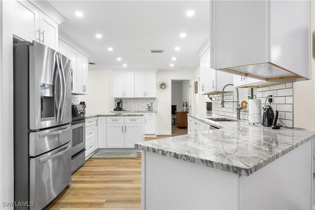 kitchen featuring sink, white cabinetry, light stone counters, kitchen peninsula, and stainless steel appliances