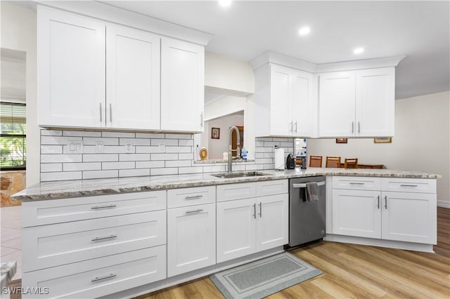 kitchen with sink, light hardwood / wood-style flooring, stainless steel dishwasher, and white cabinets