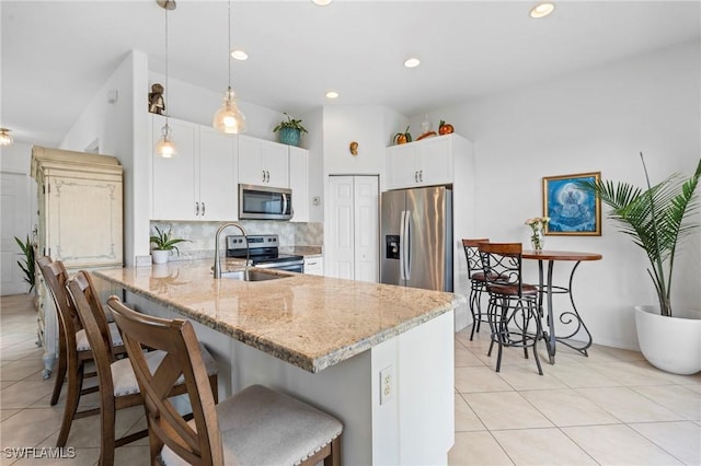 kitchen featuring sink, hanging light fixtures, stainless steel appliances, kitchen peninsula, and white cabinets