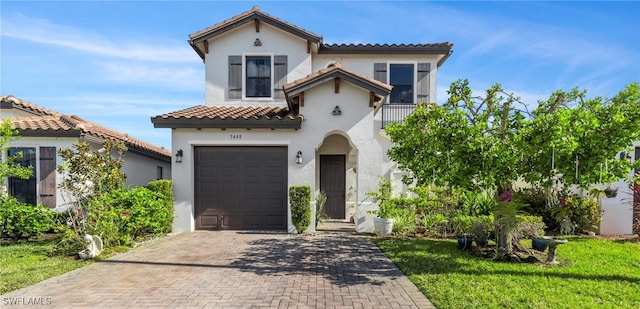 mediterranean / spanish home featuring a garage and a front lawn