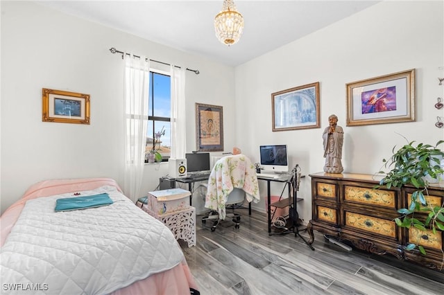 bedroom featuring hardwood / wood-style floors and a chandelier