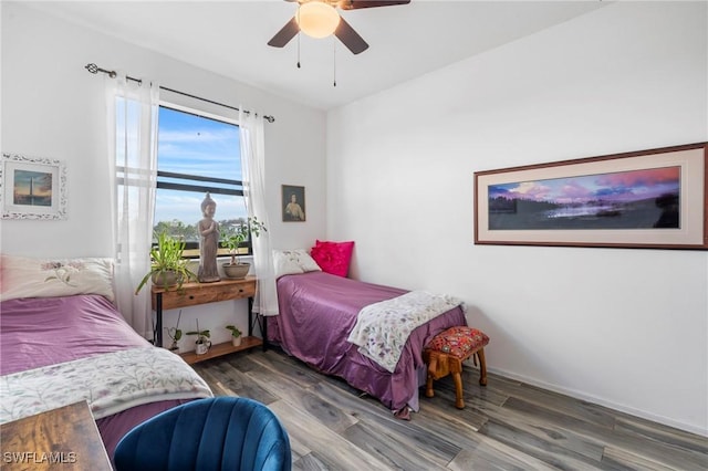 bedroom with dark hardwood / wood-style flooring and ceiling fan