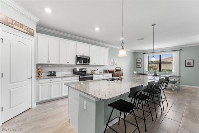 kitchen with an island with sink, sink, white cabinets, and stainless steel appliances