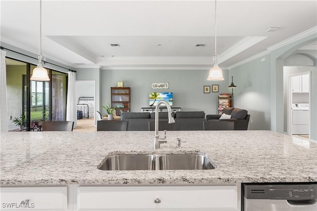 kitchen featuring a raised ceiling, white cabinetry, stainless steel dishwasher, and sink