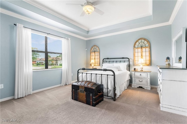 carpeted bedroom with a raised ceiling, ceiling fan, and ornamental molding