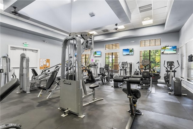 gym with a drop ceiling and a towering ceiling