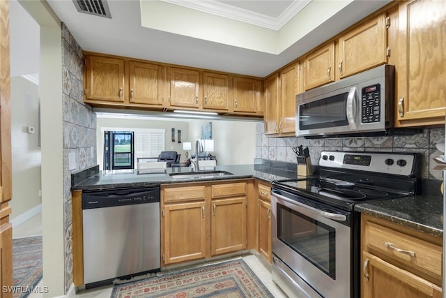 kitchen featuring visible vents, backsplash, ornamental molding, appliances with stainless steel finishes, and a sink