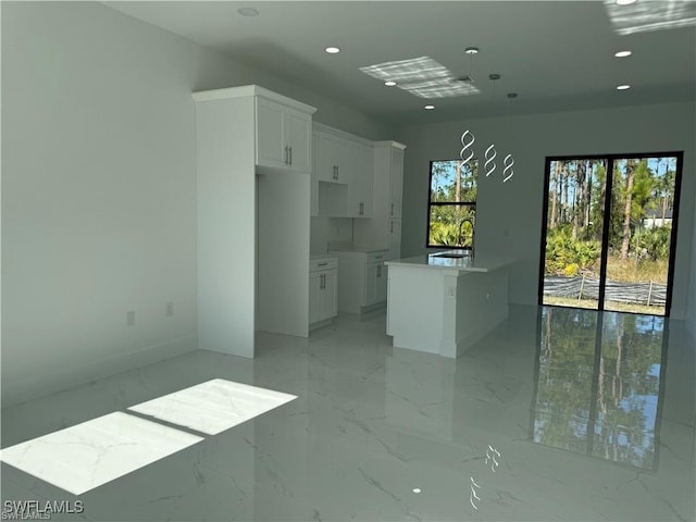 kitchen with white cabinets, sink, and a kitchen island