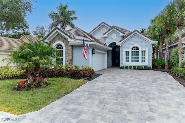 ranch-style house with a garage and a front lawn